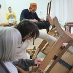 An image showing a group of people working with furniture.