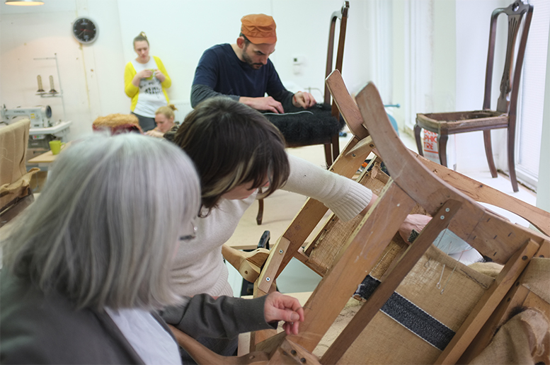 An image showing a group of people working with furniture.